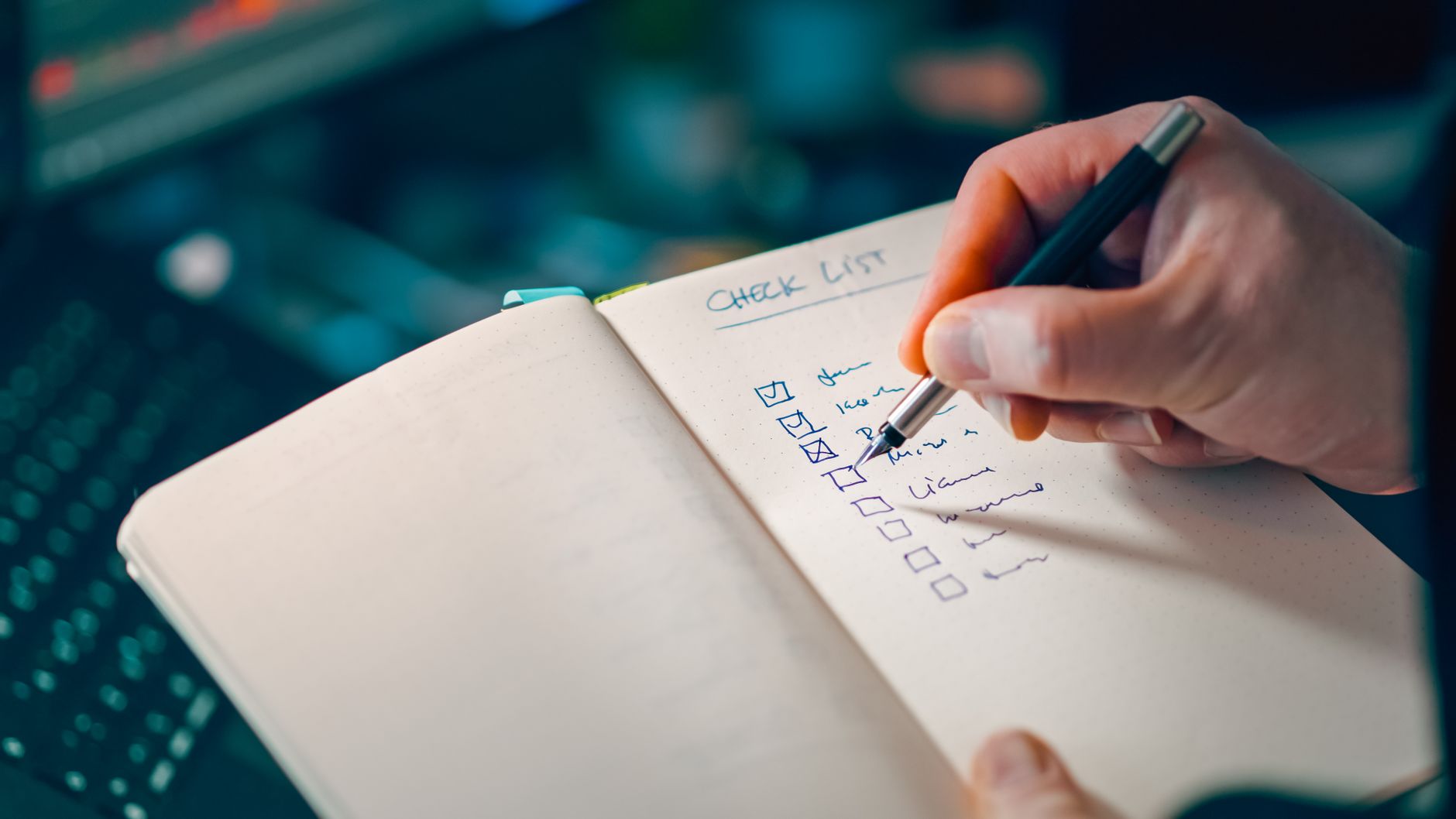 writing in notebook with checklist for task management