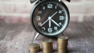 stacks of coins and an alarm clock