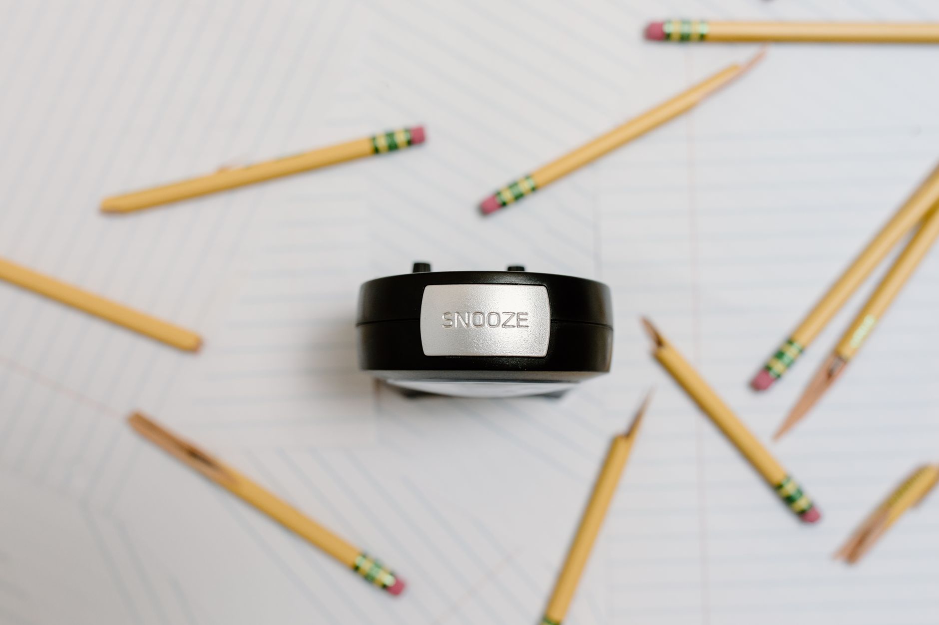 alarm clock and pencils on white background