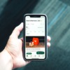 photo of a hand holding a phone with a delivery app on screen
